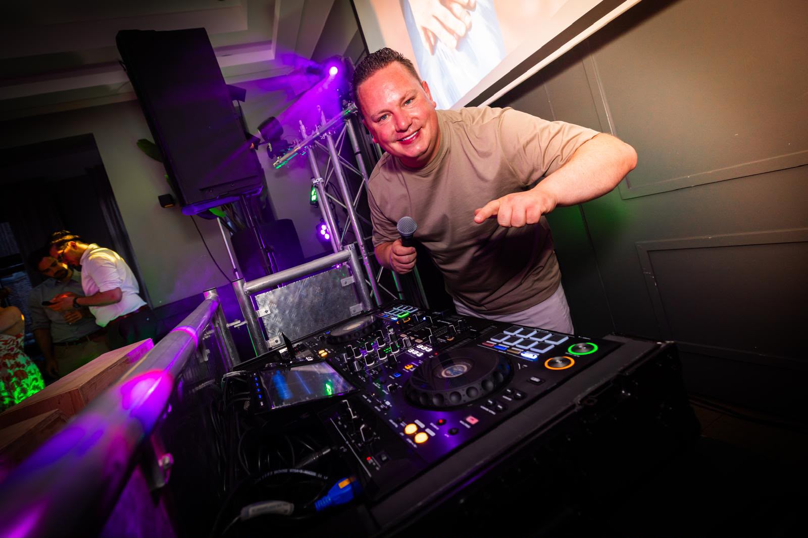 DJ Ferry van Gestel met de microfoon achter de booth tijdens een feest
